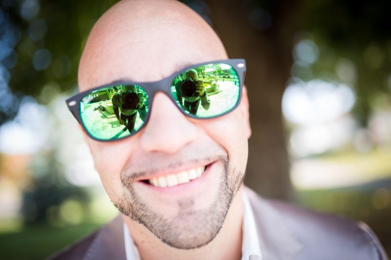 Bald adult with sunglasses smiling