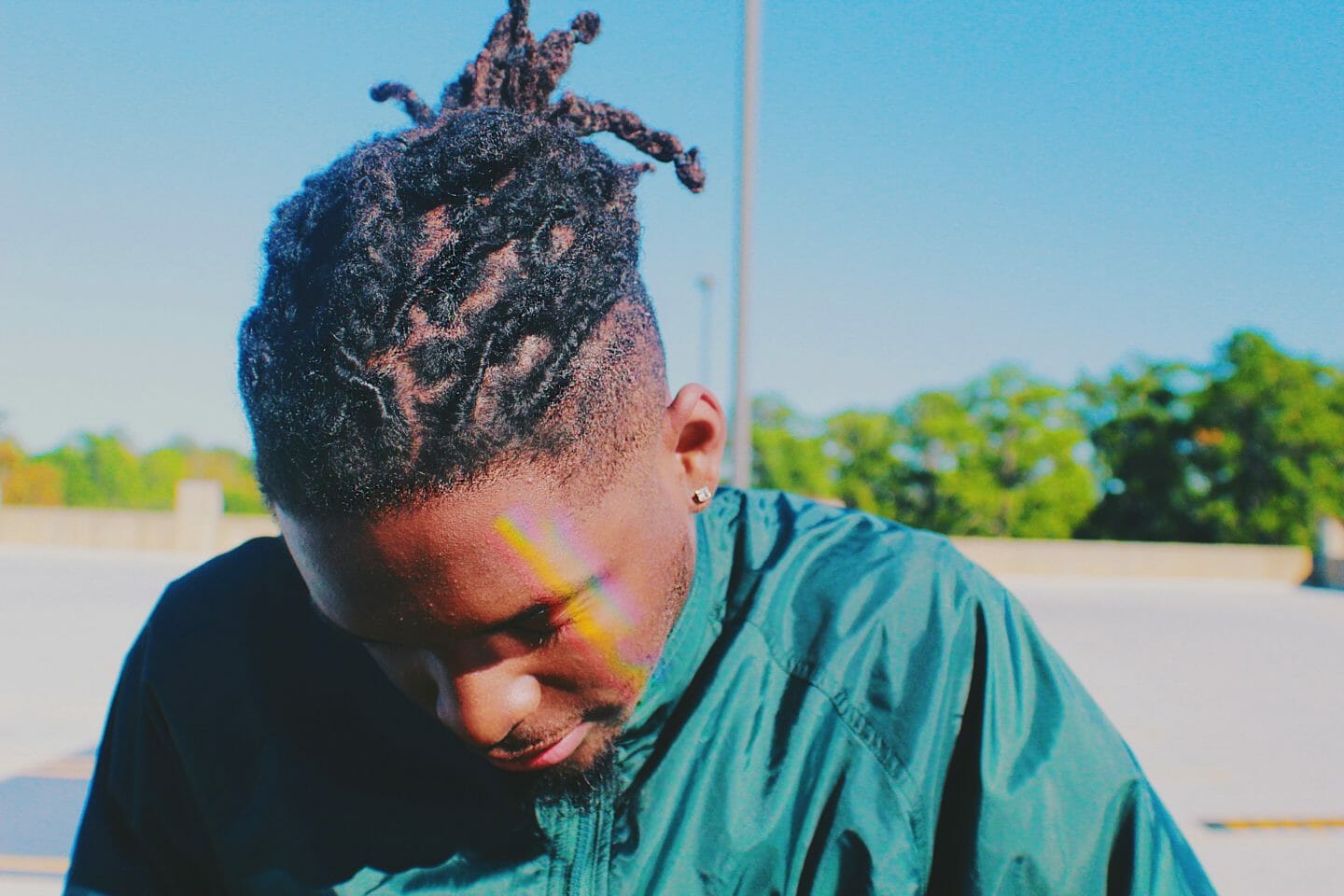 Person with dreadlocks and a sidecut looking down